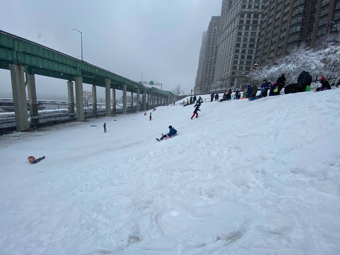 People sled down a steep hill in Riverside Park in Manhattan.
